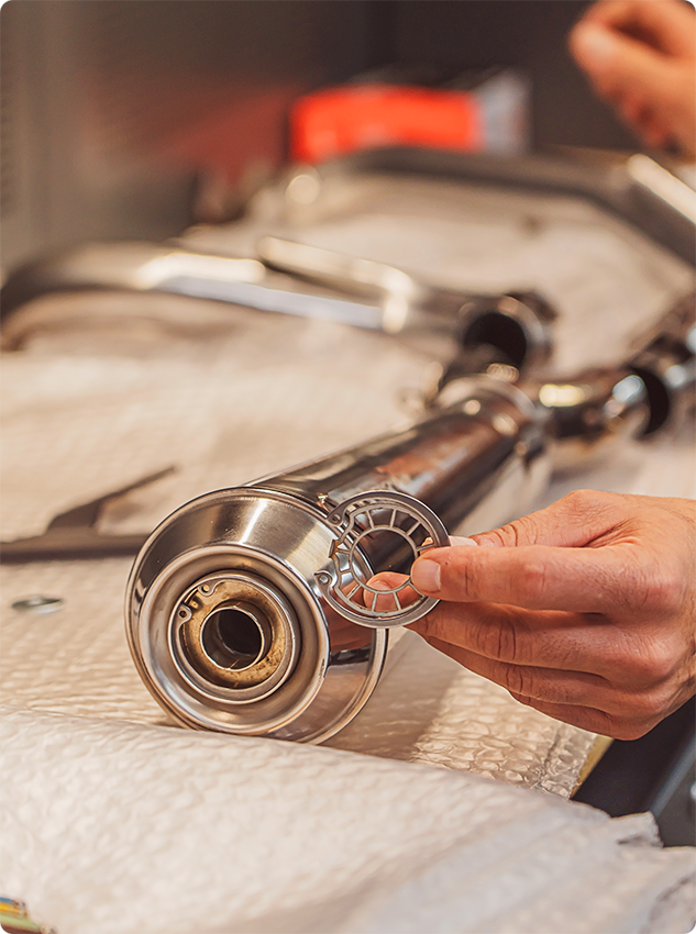 Hand showing the DB Killer of a Black Duck Fighter exhaust with the washer, CE approved and lifetime warranty
